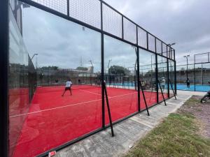 ein Netz auf einem Tennisplatz mit Leuten darauf in der Unterkunft Descanso Perfecto Ruta 34, Wifi, Cochera e Ideal para Viajeros, 3 personas in Fernández
