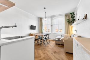a white kitchen and living room with a couch at O'Hara in Horní Blatná +9 photos