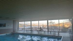 a large swimming pool with a person sitting at a table at Großes PANORAMA APARTMENT in Bingen am Rhein