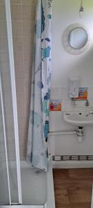 a bathroom with a shower curtain and a sink at Beside the Seaside Chalet in Mablethorpe +13 photos
