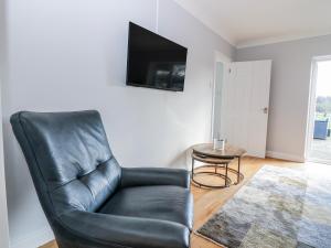 a black leather chair in a living room with a tv at Little Norwood in Perth