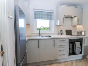 a kitchen with white cabinets and a stainless steel refrigerator at Little Norwood in Perth