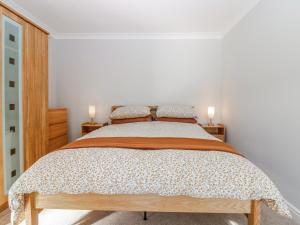 a bed in a white room with two lamps on tables at Little Norwood in Perth