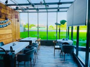 a restaurant with tables and chairs and large windows at Rambling Snail in Luodong