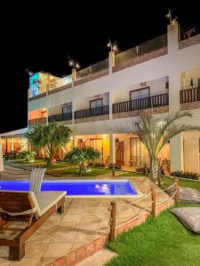 a villa with a swimming pool at night at Pousada Delta Village in Tutóia