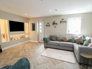 a living room with a couch and a flat screen tv at Hen Siop in Llanfairpwllgwyngyll