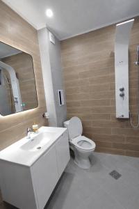 a bathroom with a white toilet and a sink at Twins Apartments in Sozopol