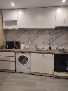 a kitchen with a washing machine and a washer at Twins Apartments in Sozopol