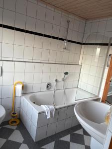 a white bathroom with a tub and a toilet at Hotel Tristan Grün in Rheine