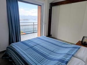 a bedroom with a bed and a large sliding glass door at La Rondinella ComoLake in Argegno