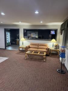a living room with a couch and two tables at Super 8 by Wyndham Chanute in Chanute +18 photos