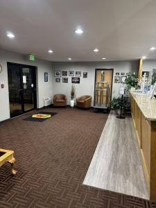 an office lobby with a waiting area with chairs and tables at Super 8 by Wyndham Chanute in Chanute