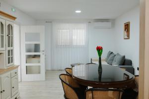 a living room with a table with a vase of flowers on it at Guest house Ivan in Međugorje