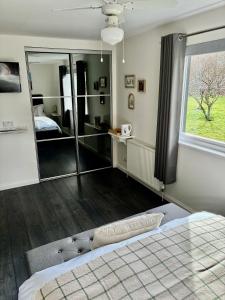 a bedroom with a bed and a large window at Craigdarroch Guest House in Contin