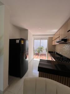 a kitchen with a black refrigerator and a counter at Casa Villa Carolina I Tu Casa en Valledupar I Lujo y Confort I Aire en todas las Habitaciones in Valledupar
