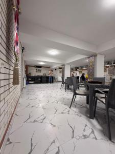 a lobby with a marble floor and tables and chairs at Abu Zarr Terrace in Bukhara