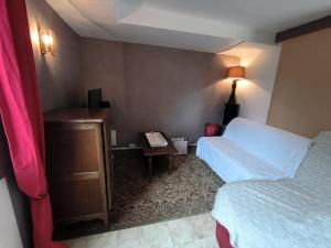 a hotel room with a bed and a desk with a phone at Replonges entre A6 et A40 in Replonges +21 photos