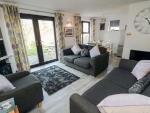 a living room with two couches and a table at Cha Cha's Cottage in Whitby