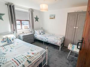 a bedroom with two beds and a sink in it at Cha Cha's Cottage in Whitby +16 photos