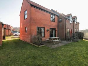 a brick house with a picnic table in the yard at Cha Cha's Cottage in Whitby