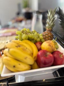 a plate of fruit with a pineapple and apples at Hotel Cittari Tatuí in Tatuí