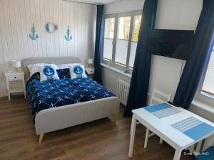a small bedroom with a bed and a table at Gryfhaus - Pokój Kapitański, 19m2, blisko plaży, parking, wysoka ocena 9,5, 2-4 osoby in Międzyzdroje +28 photos