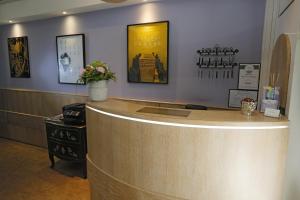 a lobby with a counter with flowers on it at Hôtel Alizé in Cannes +28 photos