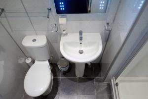 a white toilet sitting next to a sink in a bathroom at Regent House Hotel - City Centre Hotel in Edinburgh
