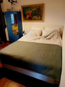a bed in a bedroom with a painting on the wall at Vila Eva in Međuvršje