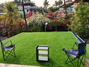 two chairs and a table on a field of grass at Richards Shared Apartment-AC in Thiruvalla +31 photos