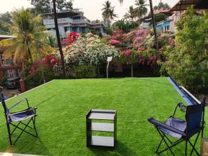 two chairs and a table on a lawn at Richards Shared Apartment-AC in Thiruvalla