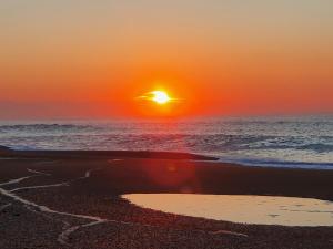 a sunset on a beach with the ocean at Les Tourtereaux in Tarnos