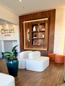 two white ottomans in a living room with aventoryventory at Hotel Cittari Tatuí in Tatuí