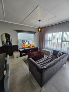 a living room with a large bed and a television at Umdloti Luxe Horizon in Umdloti