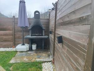 a backyard with an outdoor grill and an umbrella at ByDamla Bungalov in Sapanca