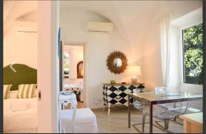 a dining room with a glass table and a bedroom at Villa Croce Anacapri in Anacapri