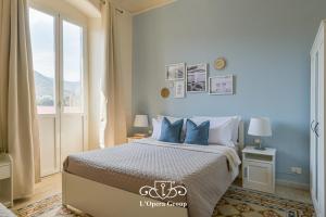 a bedroom with a bed with blue walls and a window at Vestamonti Apartment in La Spezia