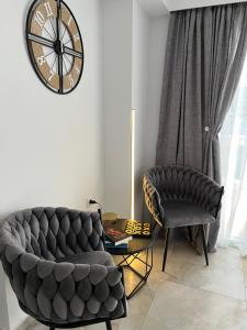 a living room with a couch and a chair and a clock at Samos Blue Haven in Samos