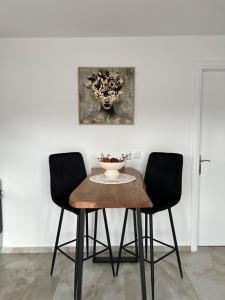 a dining room table with two chairs and a vase on it at Samos Blue Haven in Samos