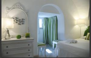 a bedroom with a bed and a dresser and a mirror at Villa Croce Anacapri in Anacapri
