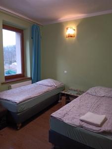 two beds in a room with a window and a bed sidx sidx sidx at Noclegi Centrum in Jelenia Góra