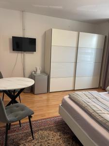 a bedroom with a bed and a table and a tv at Hotel Shelby Apartments in Garbsen