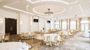 a banquet hall with tables and chairs and a chandelier at The Chateau Grande Hotel in East Brunswick