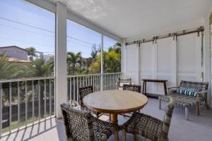 a patio with a table and chairs on a balcony at Sea U Soon - Premier 4 Bedroom Villa with Heated Pool in Captiva +28 photos