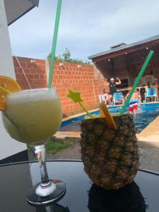 a drink and a pineapple sitting on a table at Dario Claussen house in Garupá