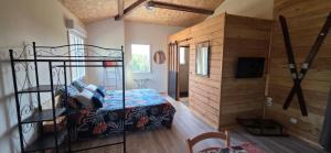 a bedroom with a bed and a wooden wall at Chambre Ephédra in Sampzon
