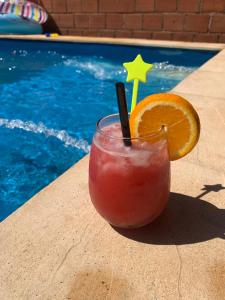 a drink with an orange slice next to a swimming pool at Dario Claussen house in Garupá