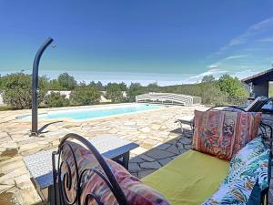 a patio with a couch and a table and a pool at Chambre Ephédra in Sampzon