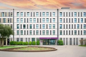 a large white building with a courtyard in front of it at Premier Inn Freiburg City Nord in Freiburg im Breisgau