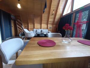 a dining room table with purple plates and a vase of flowers at ByDamla Bungalov in Sapanca